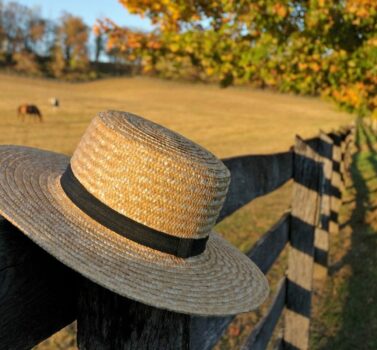 Closeup of traditional Amish straw hat in front of horse farm in the fall | Lancaster County Amish Experience in Lancaster PA